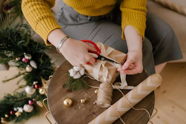 Mujer envolviendo un regalo de navidad. Aumentar las ventas en navidad.